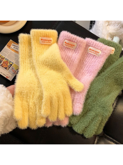Yellow, pink and green fuzzy gloves arranged together