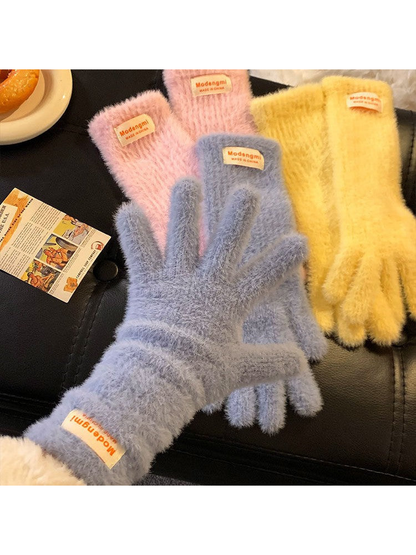 Light blue fuzzy gloves worn with the palms facing forward