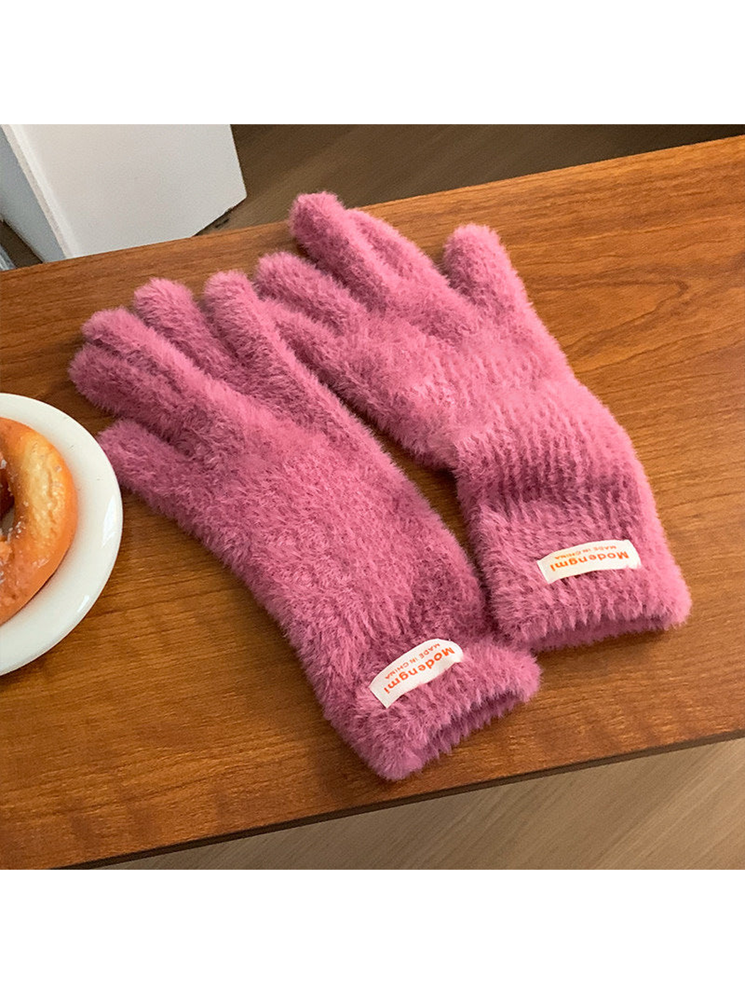 Rose pink fuzzy gloves with extended cuffs, angled view