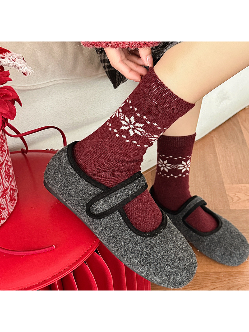 Burgundy snowflake crew socks styled with gray strap slippers