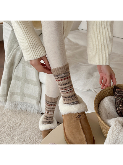 Beige geometric crew socks worn with shearling-trimmed slippers