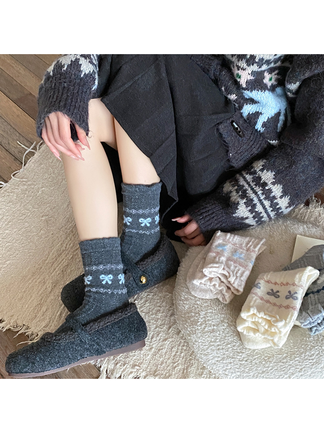 Dark gray bow-pattern crew socks styled with matching dark slippers