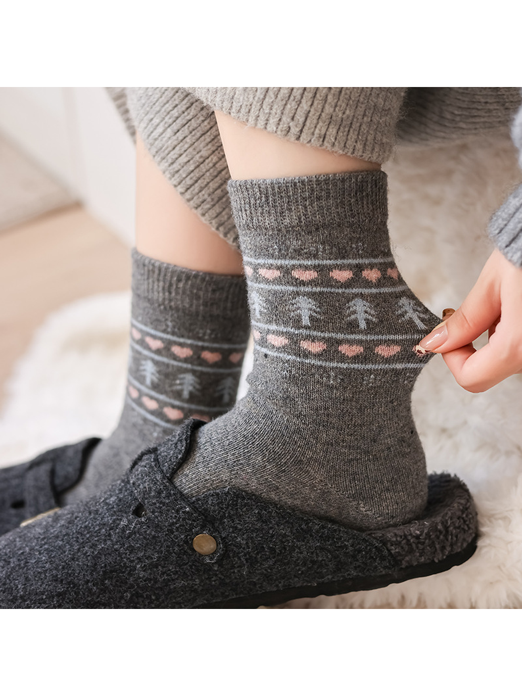 Dark gray patterned crew socks worn with charcoal clogs, close view
