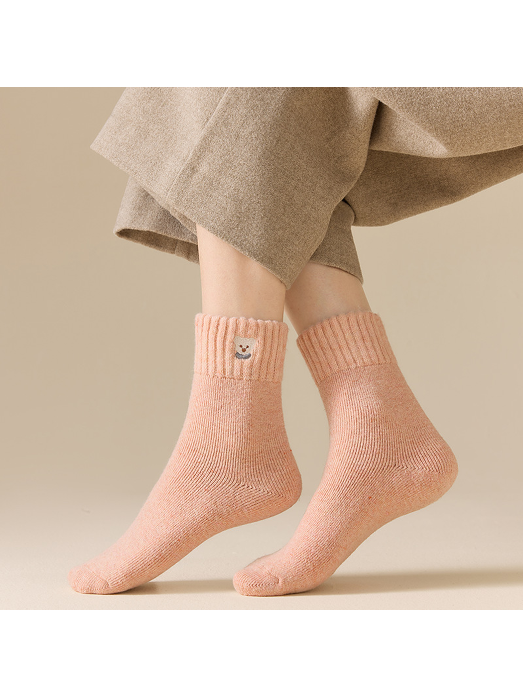 Blush pink ribbed crew socks worn in a standing side view