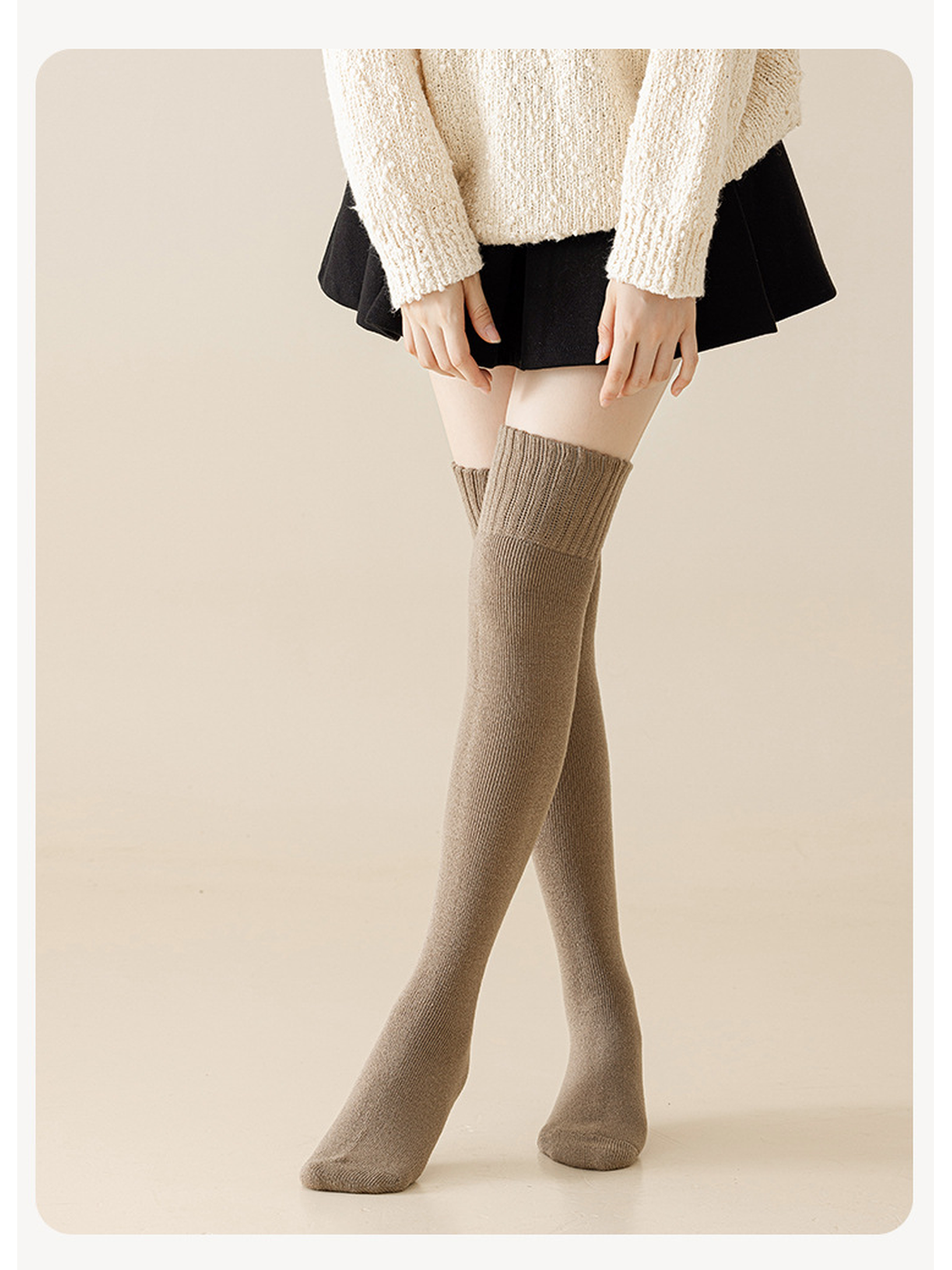 Light coffee over-the-knee socks worn with a cream sweater and black skirt