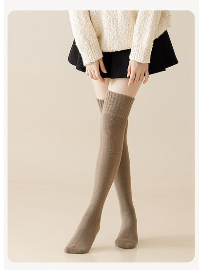 Light coffee over-the-knee socks worn with a cream sweater and black skirt