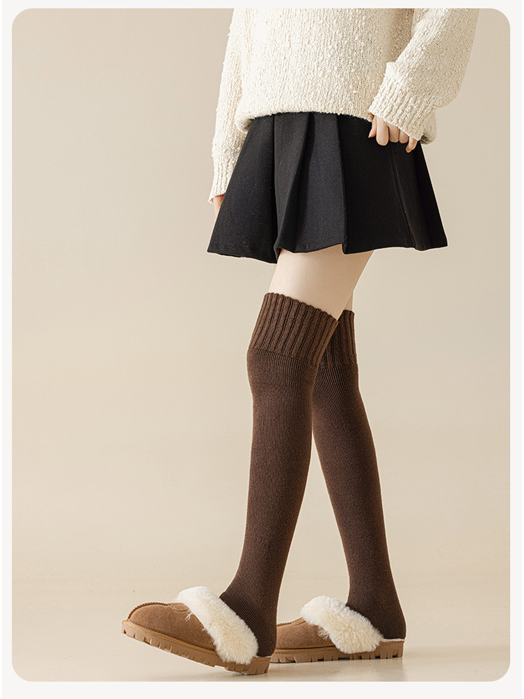 Dark coffee over-the-knee socks styled with a black skirt and fleece-lined slippers