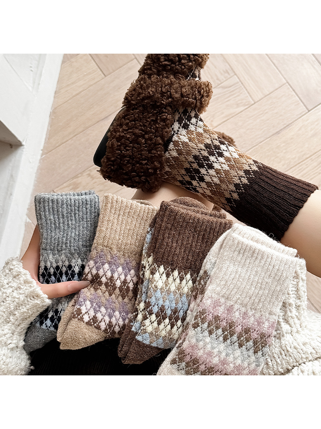 Five argyle sock colors displayed together with a dark coffee pair worn