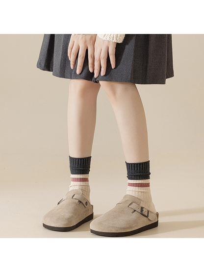 Ivory and dark gray crew socks worn loosely with taupe clogs