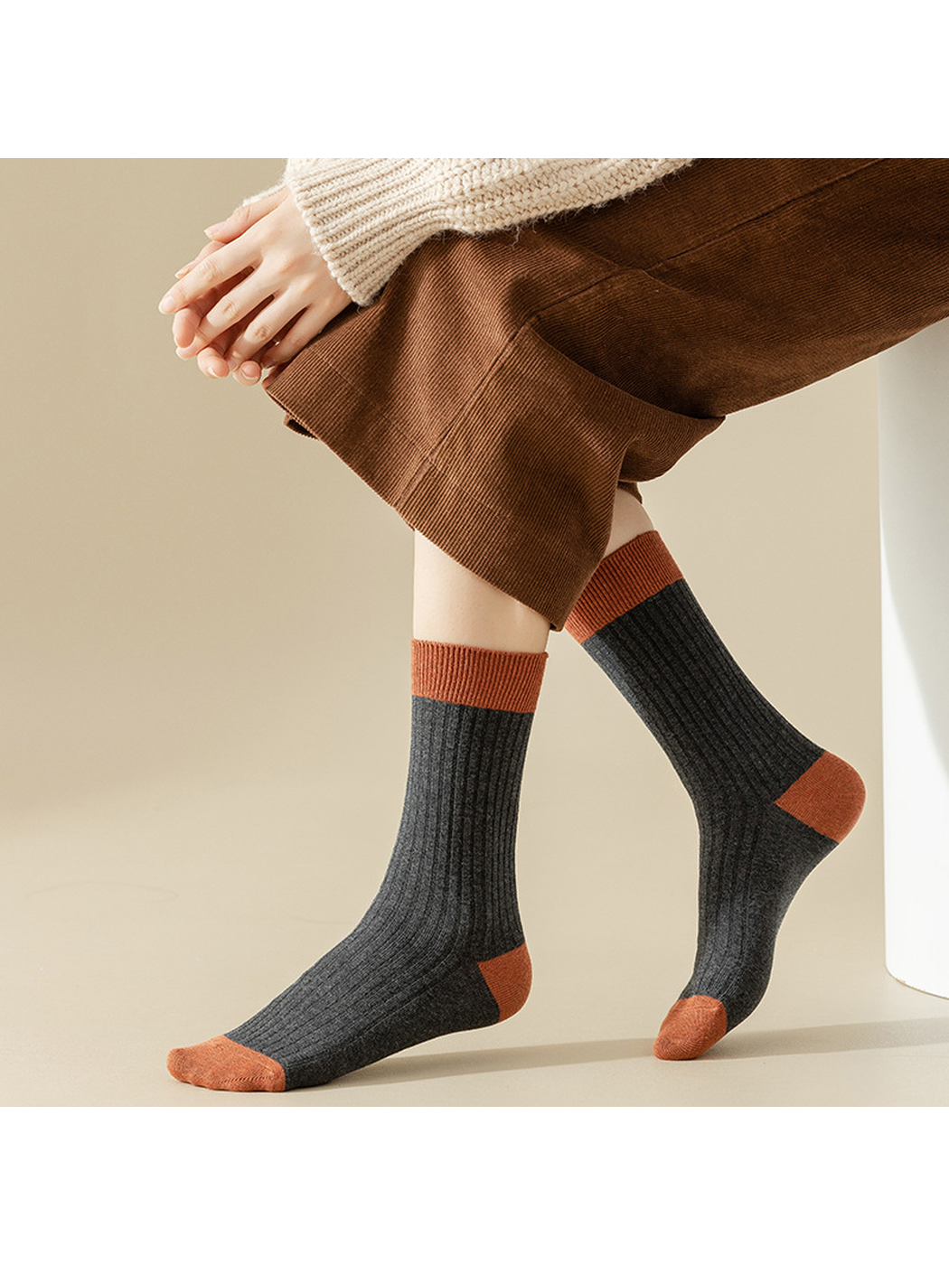 Charcoal gray ribbed crew socks with rust-colored accents, worn view