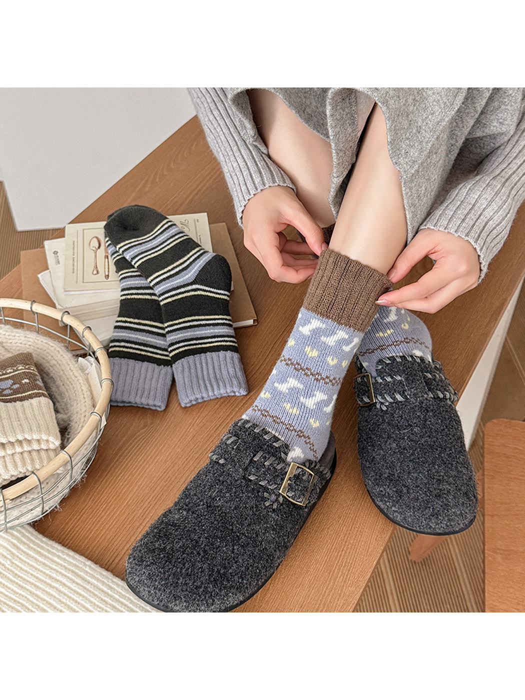 Gray-blue motif sock worn with its brown ribbed cuff being adjusted