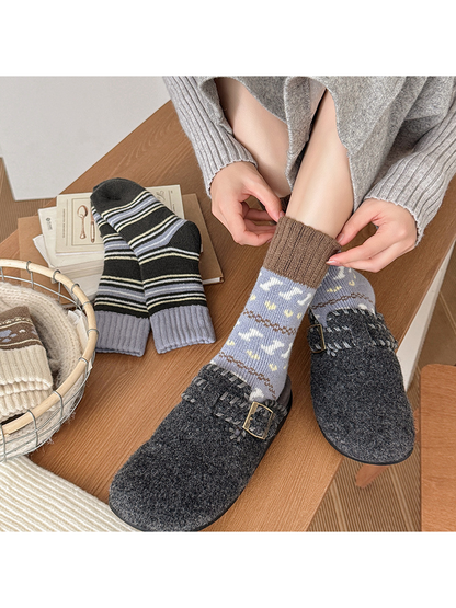 Gray-blue motif sock worn with its brown ribbed cuff being adjusted