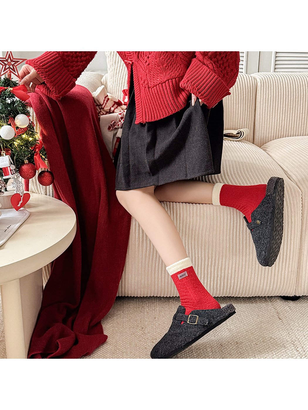 Red fuzzy crew socks worn with charcoal clogs in a holiday setting