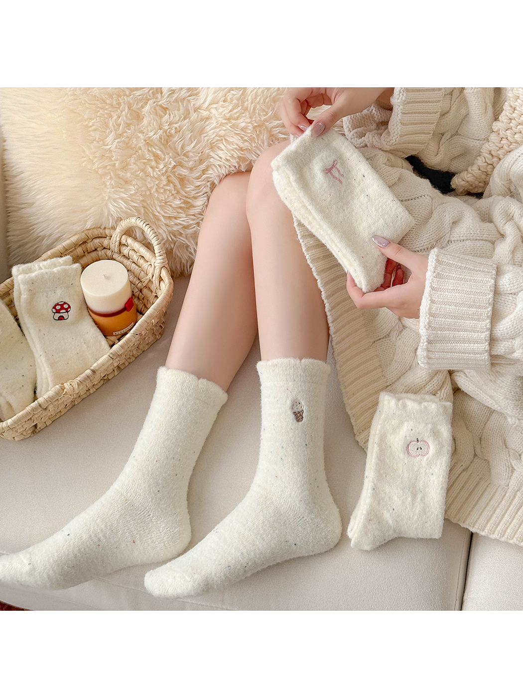 Ivory fuzzy embroidered crew socks styled on a cream sofa