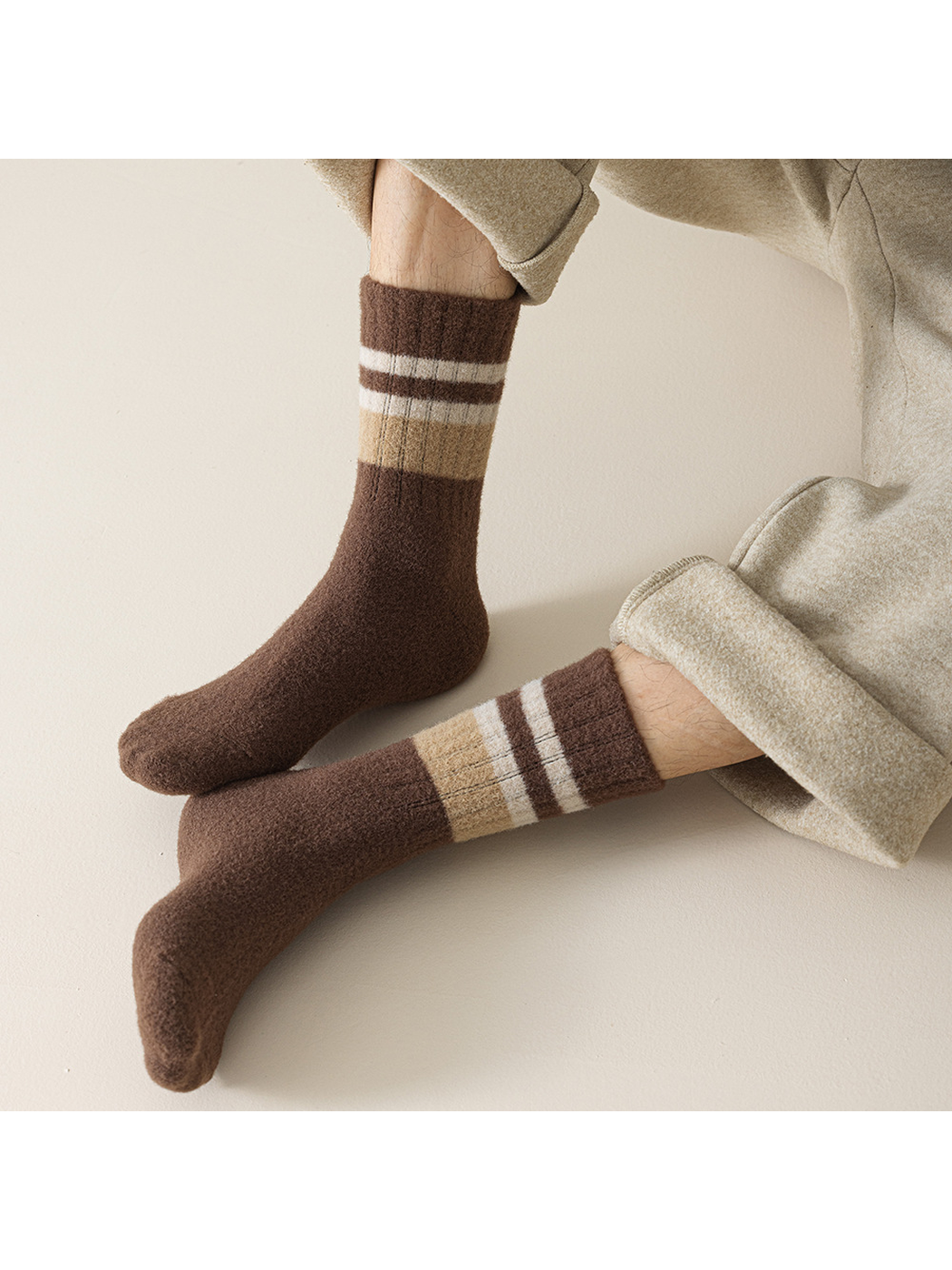 Dark brown striped crew socks worn with beige cuffed trousers