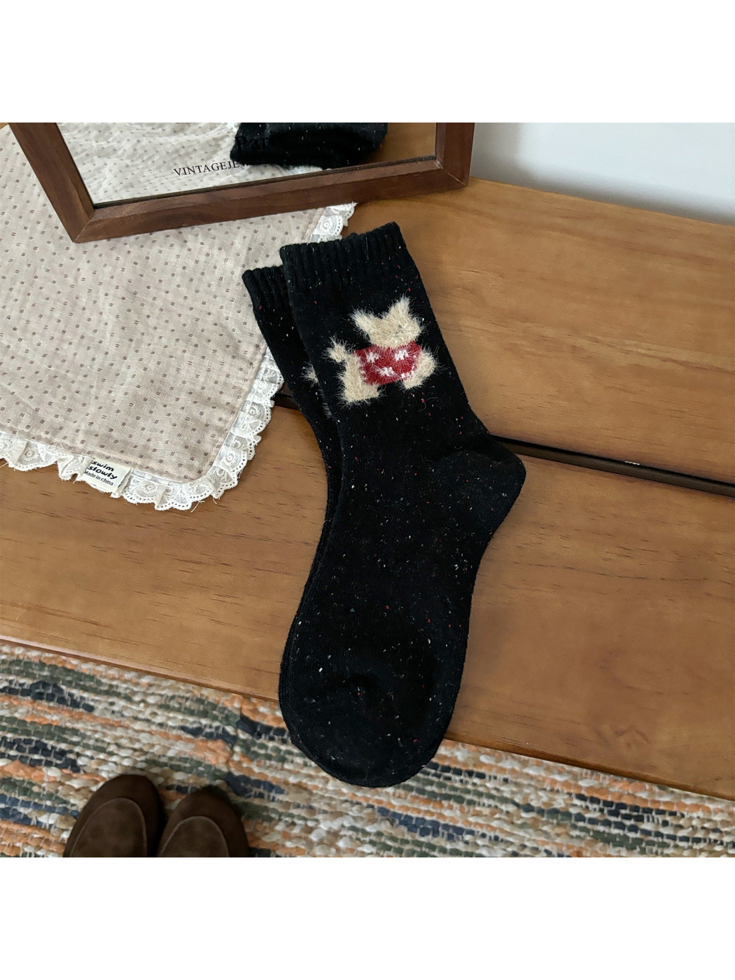 Black crew socks with a red fuzzy cat motif and ribbed cuffs