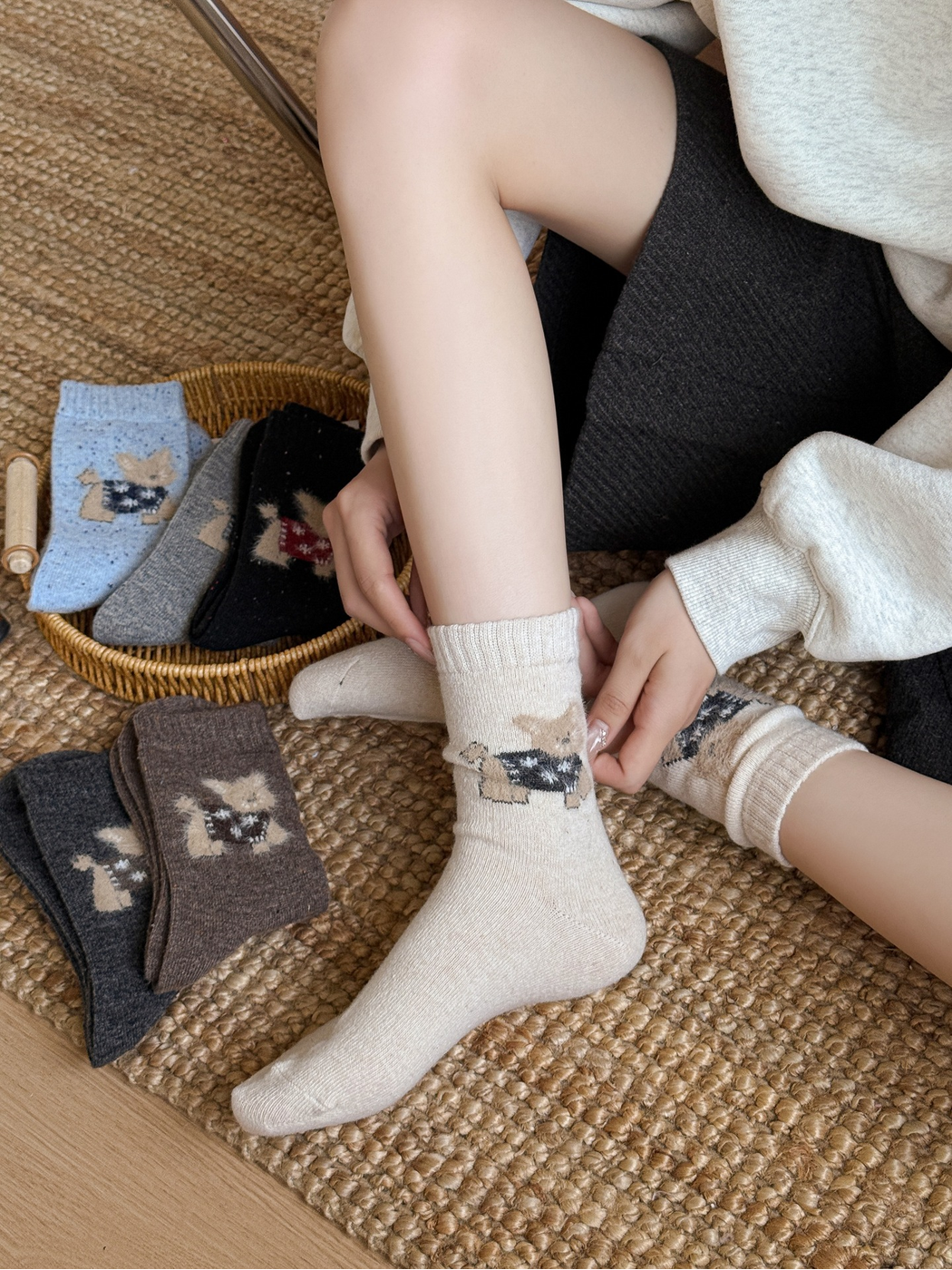 Ivory cat motif crew socks being pulled on beside other colors