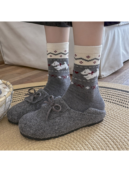 Dark gray dog-pattern crew socks worn with gray slippers