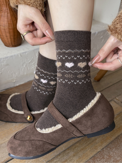 Close view of dark brown crew socks with raised fuzzy hearts worn with brown shoes