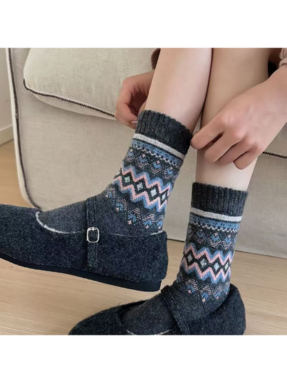 Dark gray geometric crew socks worn with charcoal strap shoes