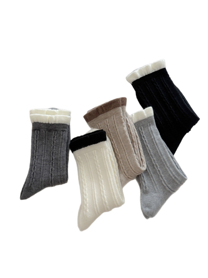 Five cable-knit crew sock colors with contrasting ruffled cuffs displayed together