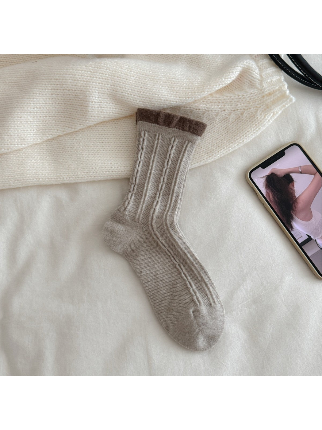 Greige cable-knit crew sock with contrasting brown ruffled cuff, flat view