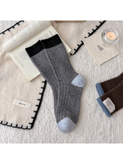 Gray speckled crew socks with black cuff and light blue accents