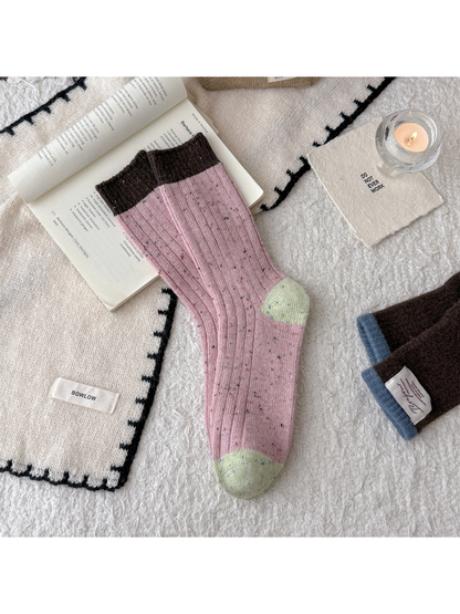 Pink speckled crew socks with brown cuff and light green accents