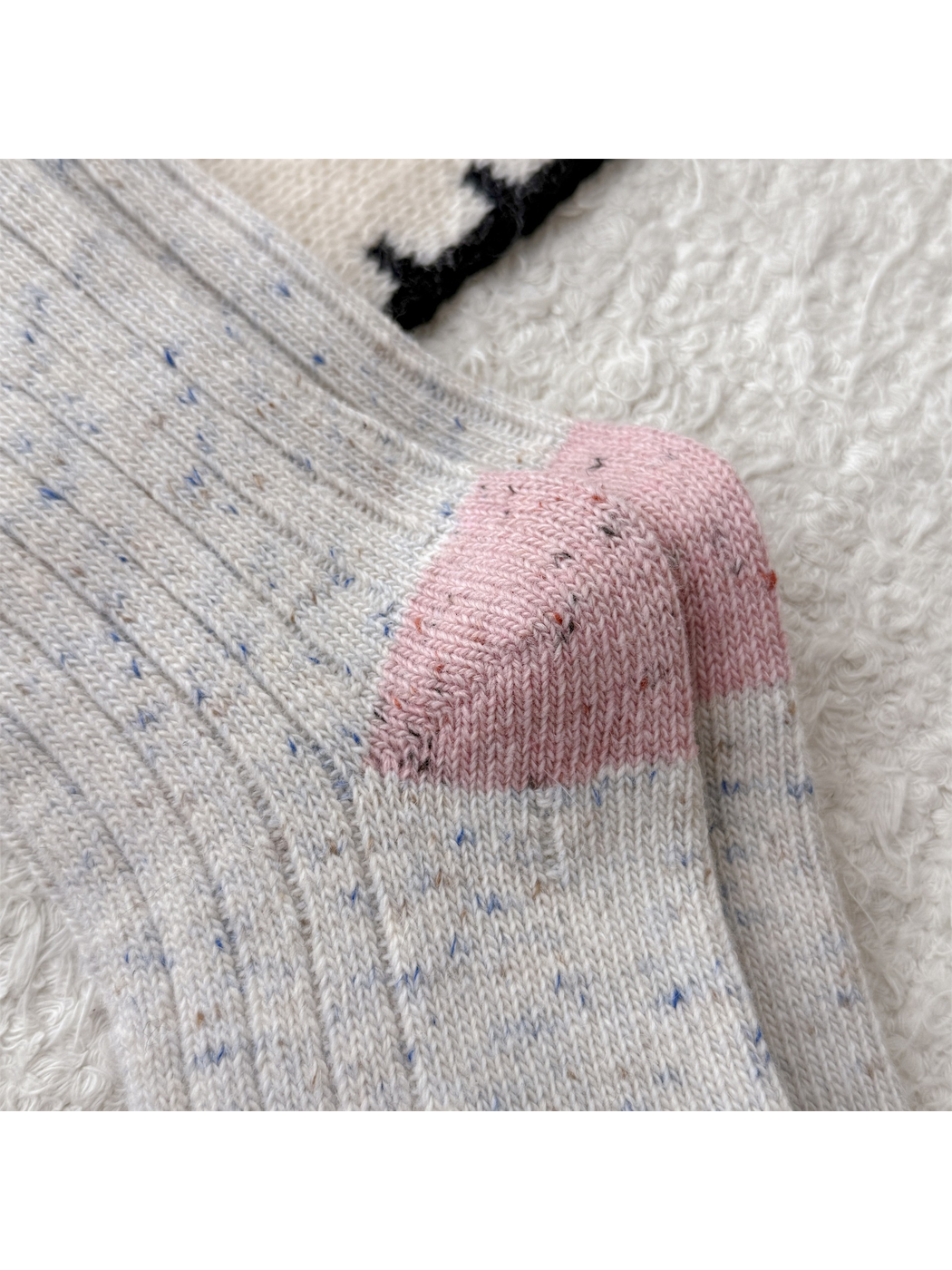 Close-up of the pink heel panels on cream speckled socks