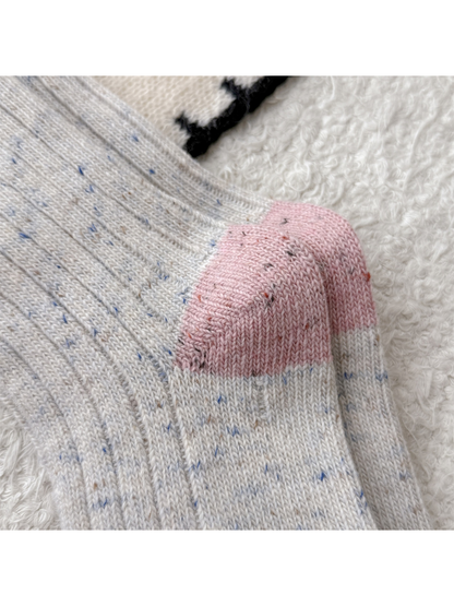 Close-up of the pink heel panels on cream speckled socks