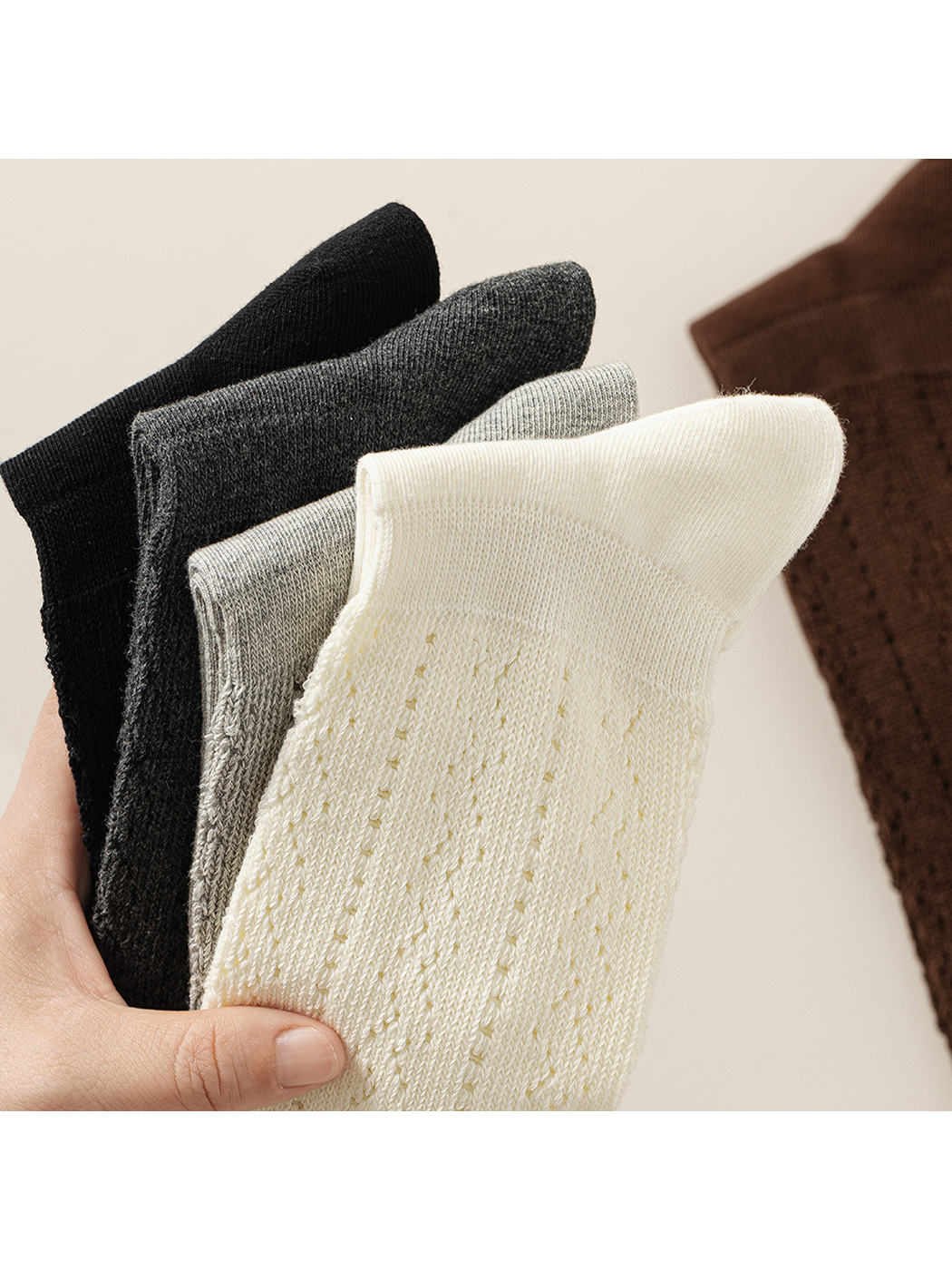 Black, dark gray, light gray and ivory pointelle socks held together