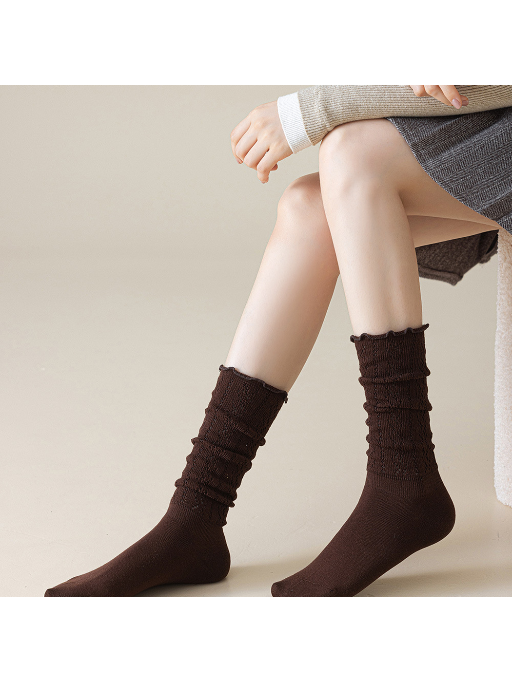 Dark brown pointelle socks worn scrunched along the lower legs
