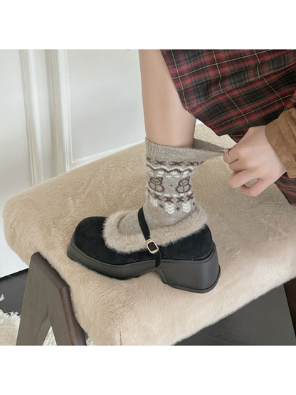 Beige bear-pattern crew sock worn with a black platform shoe