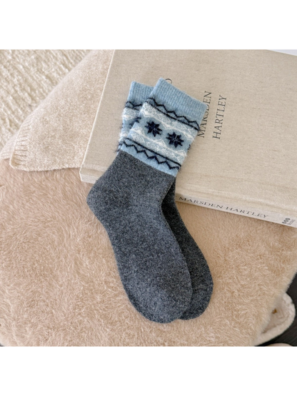 Dark gray crew socks with blue cuffs and navy snowflakes