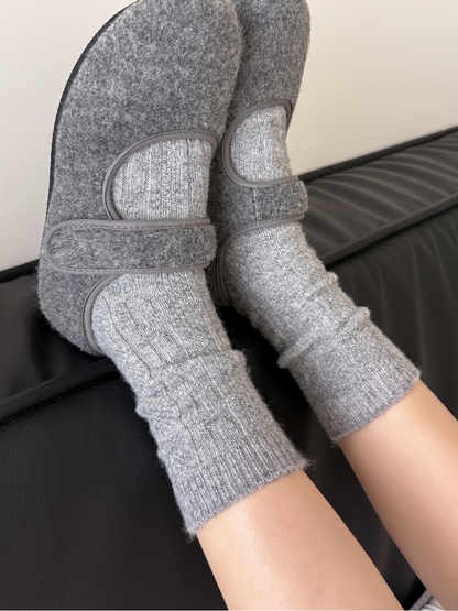Gray patterned crew socks worn with gray felt slippers