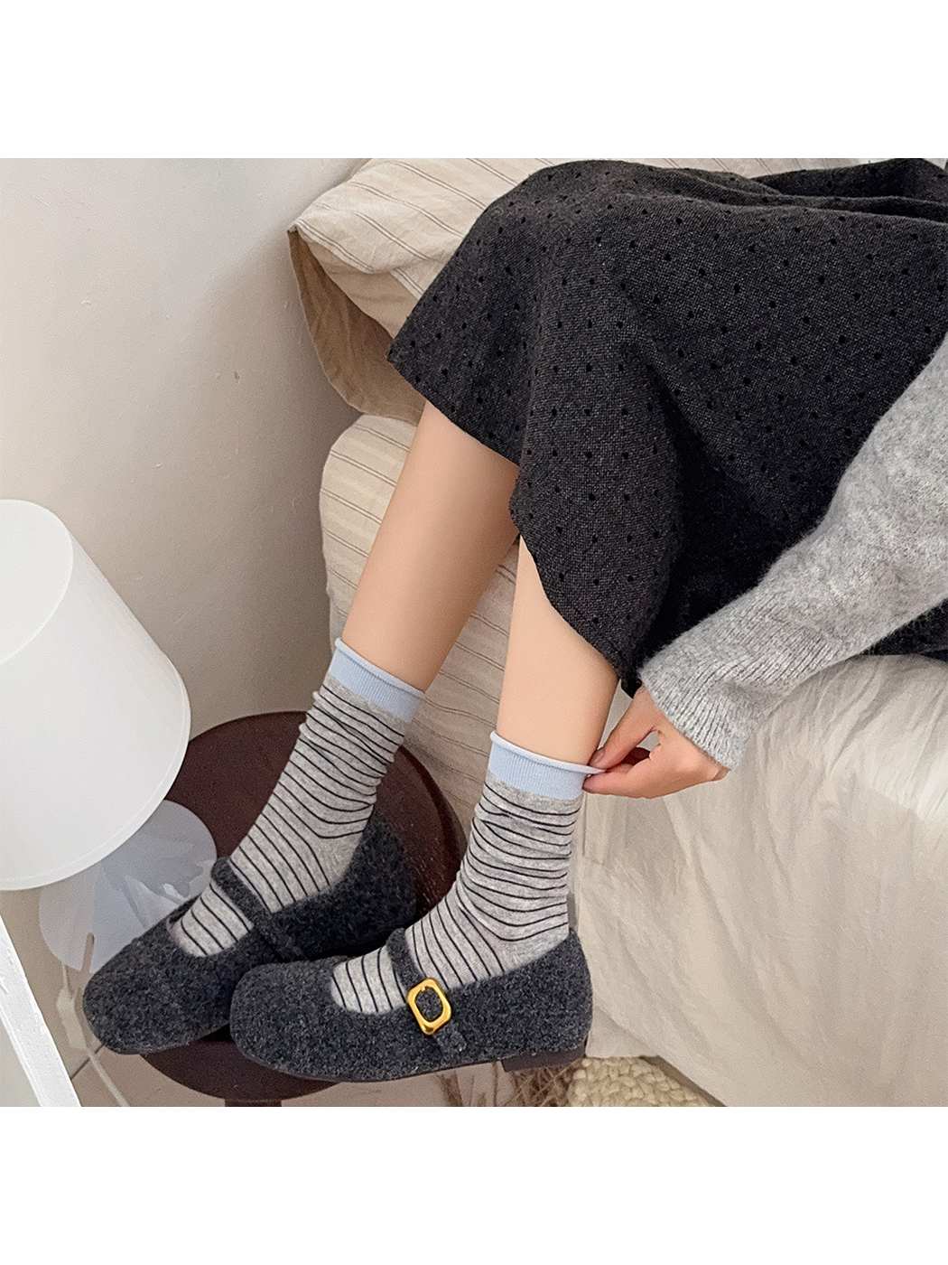 Light gray striped crew socks with blue cuffs styled with dark flats