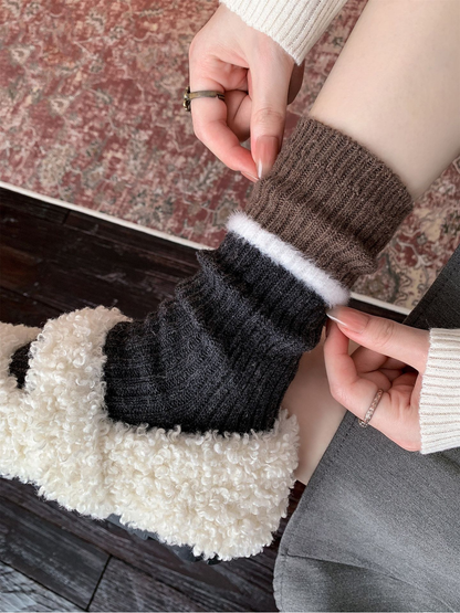 Close-up of a gray ribbed sock with a brown cuff and white fuzzy stripe