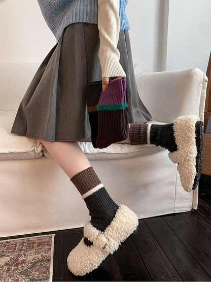 Color-blocked ribbed socks styled with a gray skirt and fuzzy clogs