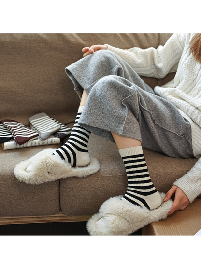 Ivory crew socks with black stripes styled with plush slippers