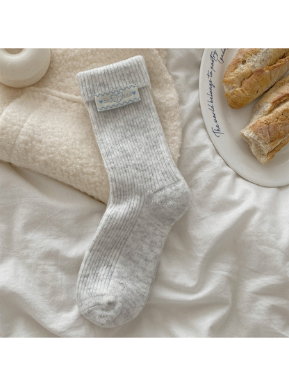 Light gray ribbed crew sock with fold-over cuff and heart label