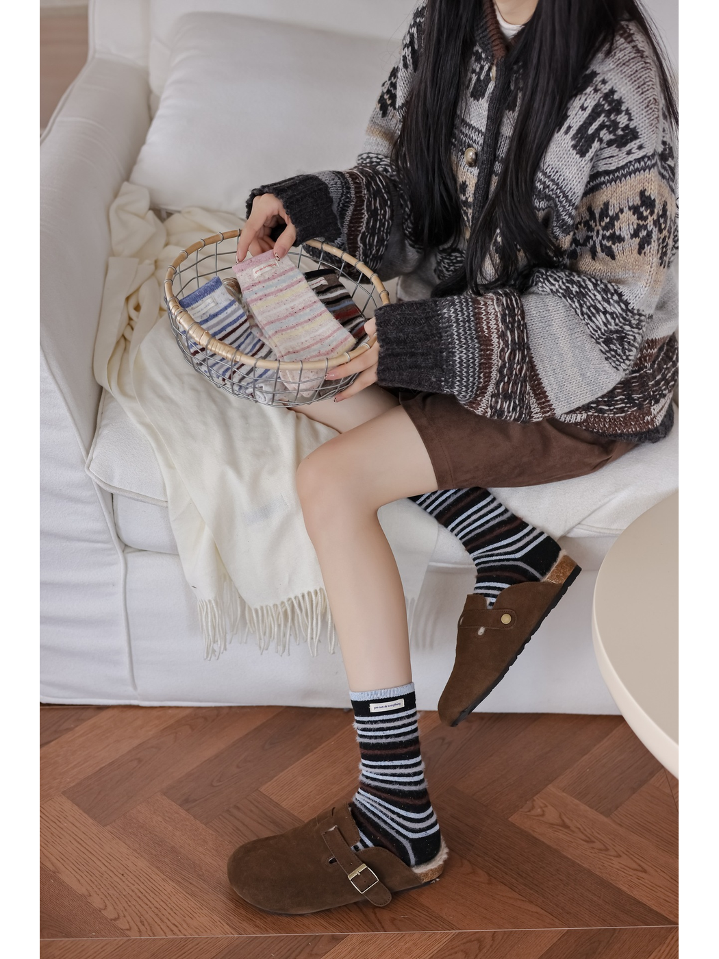 Black striped crew socks styled with brown clogs and a patterned cardigan
