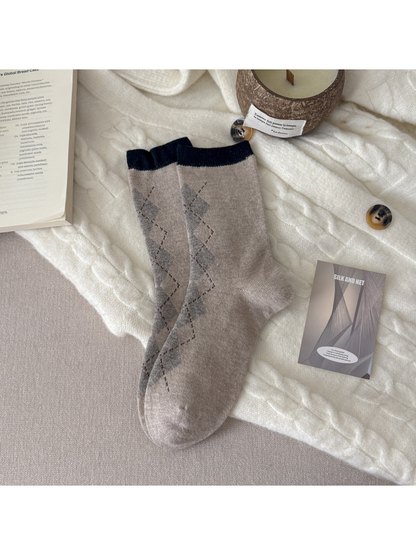 Beige crew socks with gray argyle diamonds and contrasting black cuffs