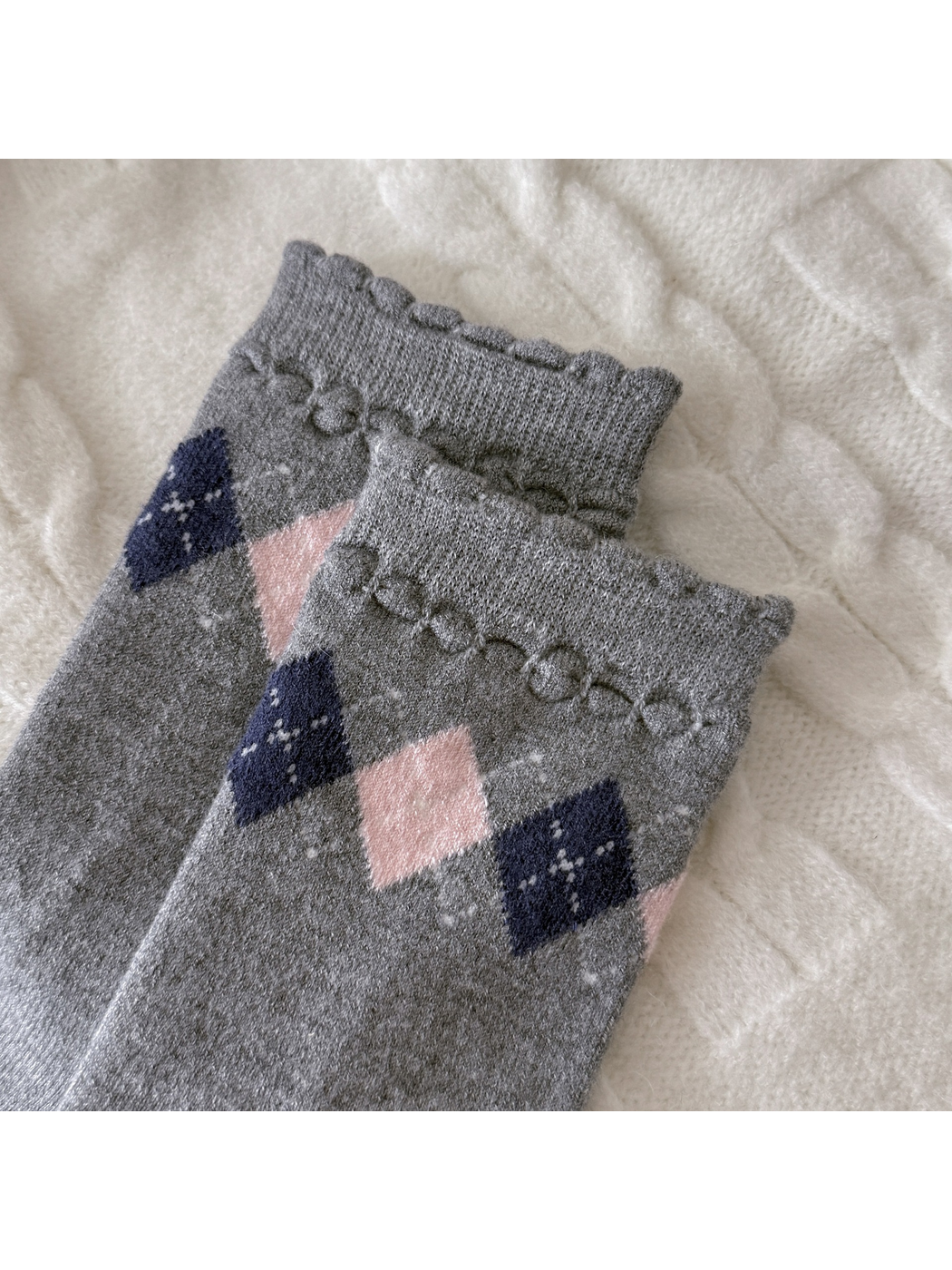 Close-up of scalloped sock cuffs with raised looped trim and diamond patterns