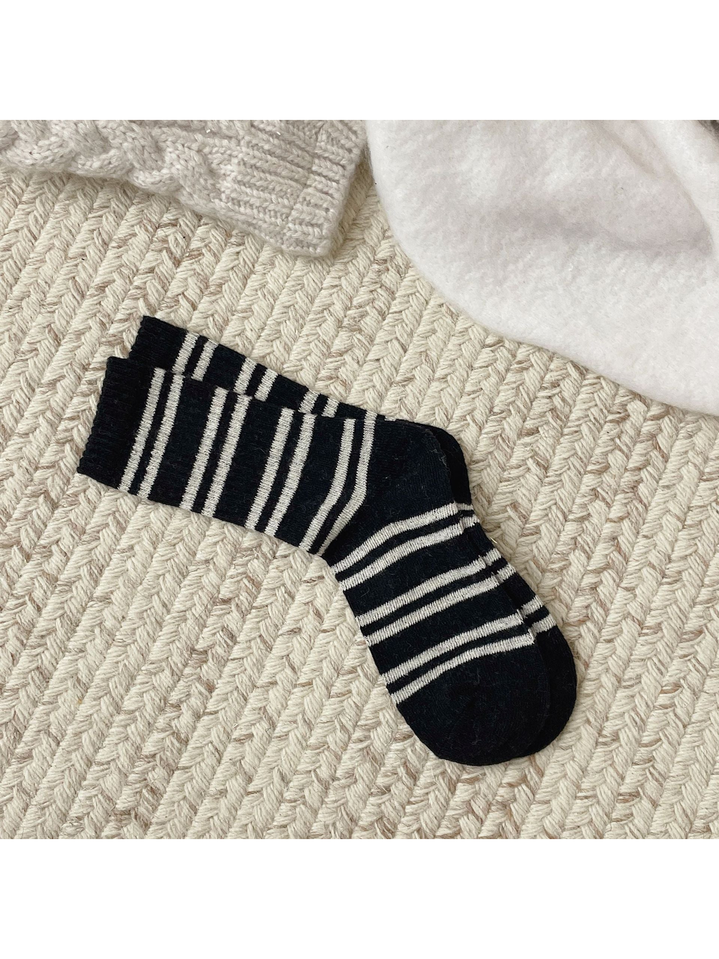 Black crew socks with irregular ivory stripes, full pair view