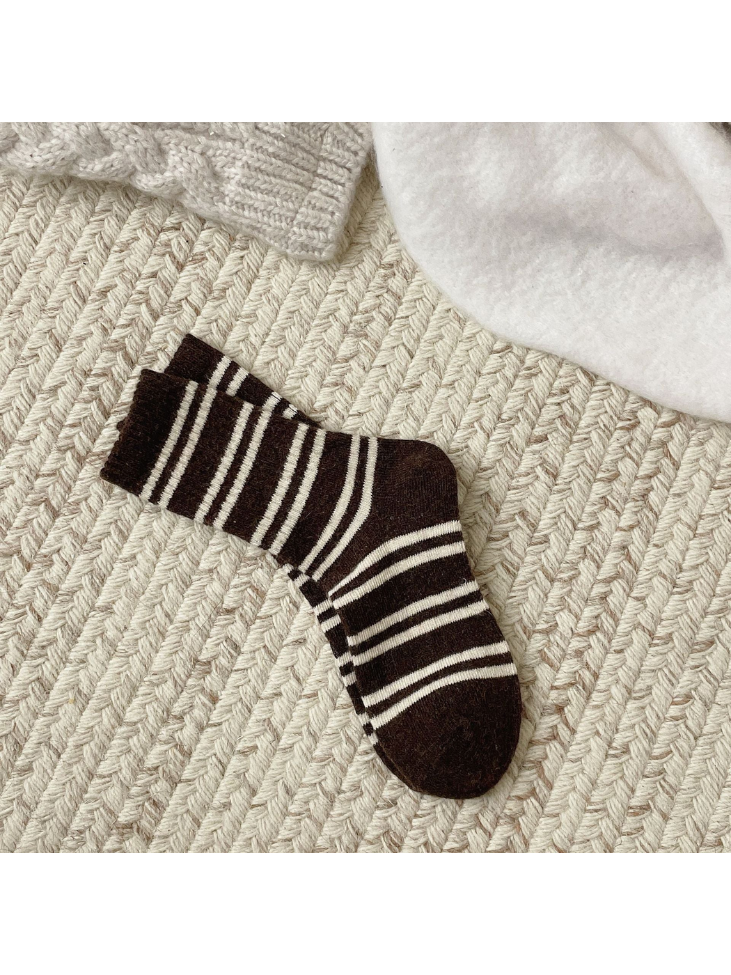 Dark brown crew socks with irregular ivory stripes, full pair view