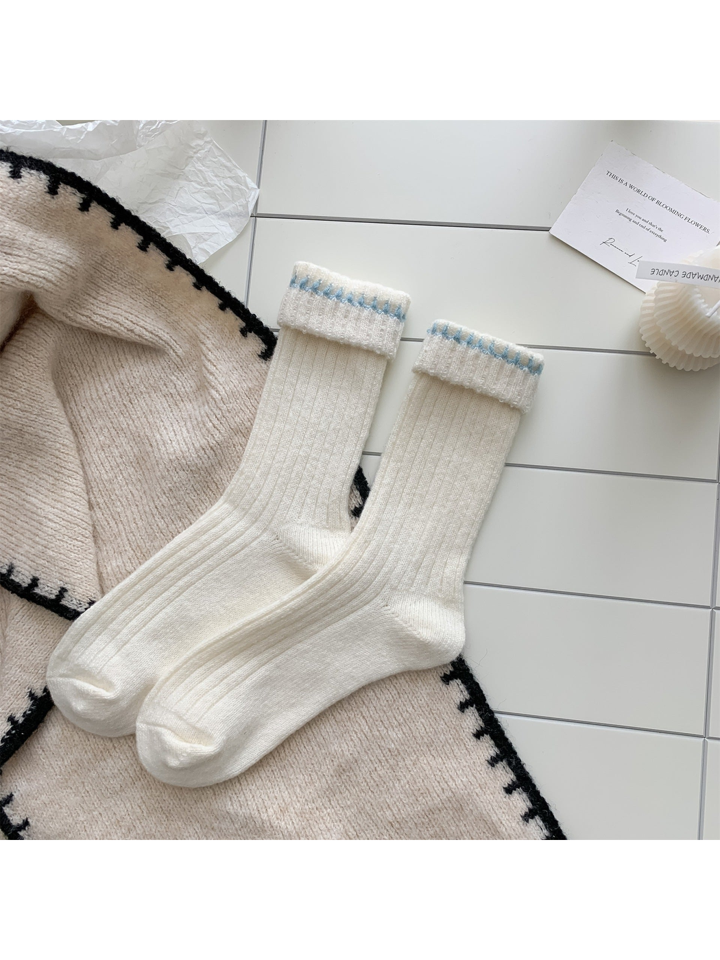 Ivory ribbed crew socks with blue contrast stitching, pair laid flat