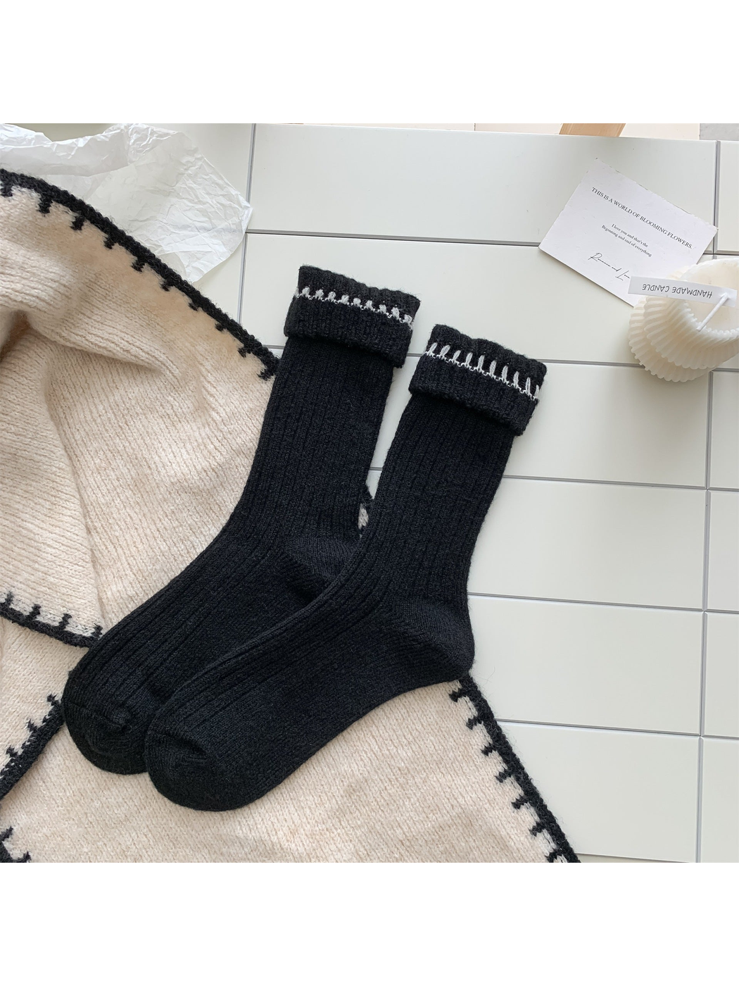 Black ribbed crew socks with white contrast stitching, pair laid flat