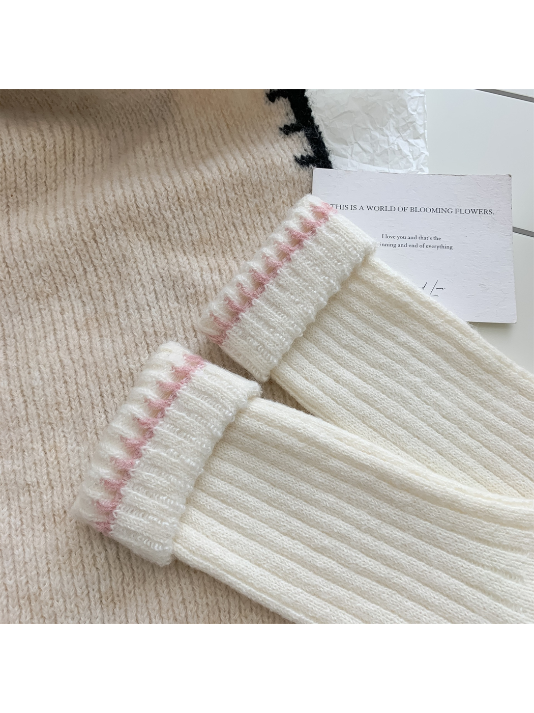 Close-up of ivory ribbed sock cuffs with pink contrast stitching