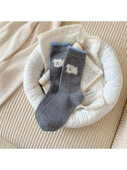 Dark gray crew socks with a cream fuzzy animal motif and blue cuff trim