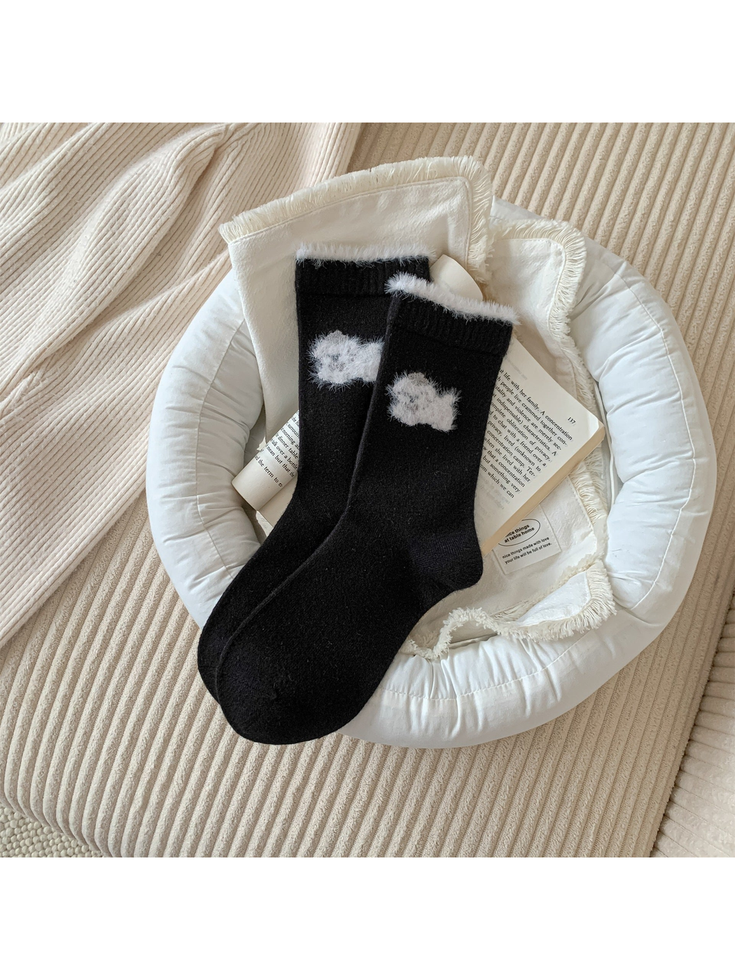 Black crew socks with a white fuzzy animal motif and cuff trim
